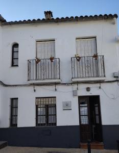 a white building with two balconies and a door at El rinconcito in Fuenteheridos