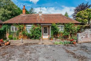 a small brick house with a white door at Beautiful Riverside Cottage with Large Garden, 2BR in Boldre