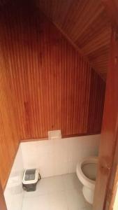 een badkamer met toilet en houten wand bij Habitación en lindo Apartamento in Pasto