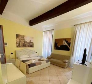 a bedroom with a bed and a couch at DIMORA AL SARACENO in Ferrara