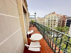 a balcony with a table and chairs on a building at Rooms in Apartment Rambla Catalunya in Barcelona