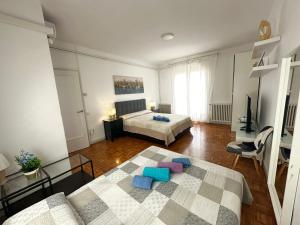 a large room with two beds and a television at Rooms in Apartment Rambla Catalunya in Barcelona
