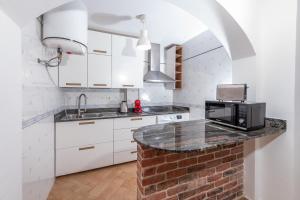a kitchen with white cabinets and a counter with a microwave at Calas Beach Corralejo in Corralejo