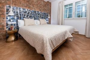 a bedroom with a bed with a brick wall at Calas Beach Corralejo in Corralejo