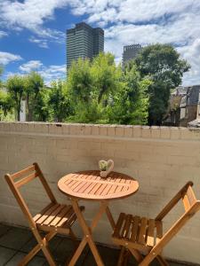 a wooden table and two chairs on a patio at Lovely Entire Flat with Private Balcony in Euston-Central London in London