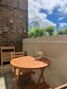 a wooden table and chairs on a patio at Lovely Entire Flat with Private Balcony in Euston-Central London in London