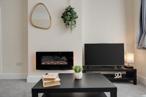 a living room with a tv and a coffee table at Large cosy house - free on street parking in Liverpool