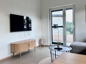 a living room with a couch and a tv on a wall at Ferienwohnung Schottenhof Walser 3 - Alleinlage im Grünen mit Panoramablick in Achberg