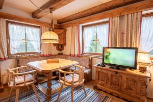 a dining room with a table and a television at Haus Steinbock Top 1 in Krimml