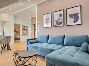 a living room with a blue couch and a table at HOMEBASE - Design Lofts am Schloss in Montabaur