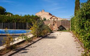 Un patio trasero con piscina y valla. en Maison Roxane, en Curet