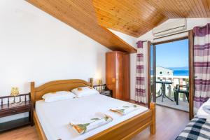 a bedroom with a bed and a view of the ocean at Apartments with parking space Supetar, Brac - 5670 in Supetar
