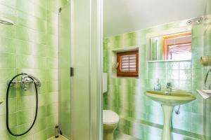 a green tiled bathroom with a sink and a shower at Apartments with parking space Supetar, Brac - 5670 in Supetar