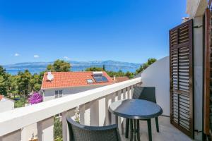 a balcony with a table and chairs and a view at Apartments with parking space Supetar, Brac - 5670 in Supetar