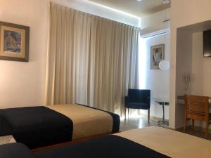 a hotel room with a bed and a chair at Hotel Roma in Cosamaloapan de Carpio +36 photos