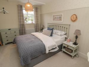 a bedroom with a bed and a table with a lamp at The Olde Stables in Morpeth