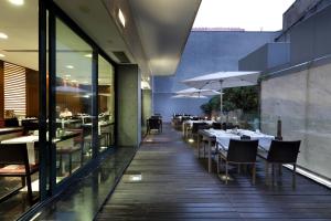 a restaurant with tables and umbrellas on a balcony at Eurostars Das Letras in Lisbon