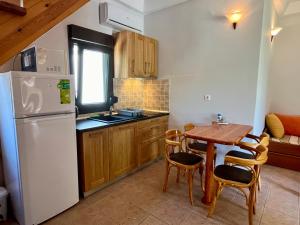 a kitchen with a table and a white refrigerator at Oneiro Zois villas in Prinos