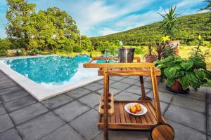 a table with a bowl of fruit on a patio at Stone Garden Villa, Heated Pool & Outdoor Cinema in Trilj