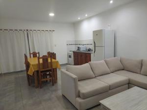 een woonkamer met een bank en een tafel en een keuken bij La casita de Isa 2 in Gualeguay