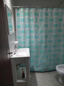 een badkamer met een wastafel en een douchegordijn bij La casita de Isa 2 in Gualeguay