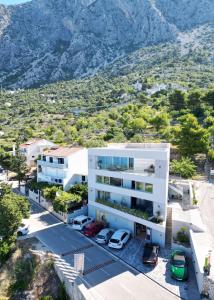 una vista aerea di un edificio bianco con montagne sullo sfondo di Apartments by the sea Drasnice, Makarska - 21341 a Drasnice