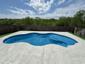 a small swimming pool in a backyard with a fence at Stylish Family Home Near Lackland POOL in San Antonio