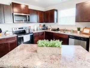 a kitchen with wooden cabinets and a granite counter top at Stylish Family Home Near Lackland POOL in San Antonio