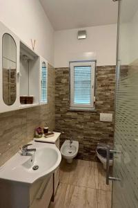 ein Badezimmer mit Waschbecken, Toilette und Dusche in der Unterkunft Family friendly apartments with a swimming pool Pula - 22040 in Pula