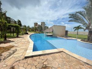 a swimming pool in a resort with palm trees at Shamballa - luxury house and apartments in São Miguel do Gostoso