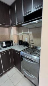 d'une cuisine équipée d'une cuisinière en acier inoxydable et de placards. dans l'établissement Departamento alta categoría, à Barrio Rivadavia 6 autres photos