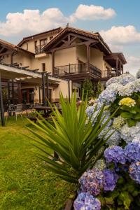 a house with a bunch of flowers in front of it at Hotel Rural Playa de Aguilar in Muros de Nal&oacute;n