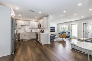 a kitchen and living room with white cabinets and a table at Heated Pool - 1 Mile to Beach - FirePit in Pompano Beach