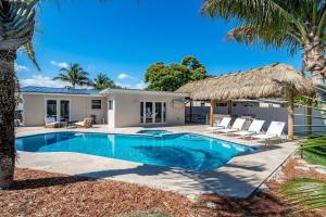 a villa with a swimming pool and palm trees at Heated Pool - 1 Mile to Beach - FirePit in Pompano Beach