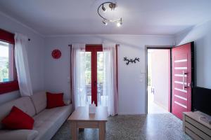 a living room with a couch and a tv at Oregano peaceful complex in Porto Rafti
