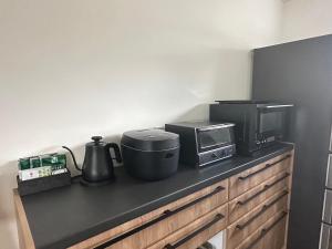 a kitchen counter with a microwave and a appliance on it at Villa SUN58 ヴィラサンゴエイト in Miyako-jima