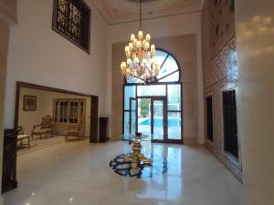 una gran sala de estar con una lámpara de araña y una mesa en Hamamat, en Hammamet Sud