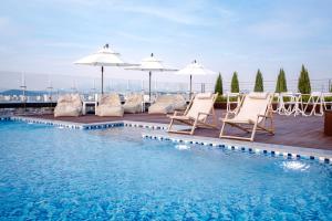 Eine Reihe von Stühlen und Sonnenschirmen neben einem Schwimmbecken in der Unterkunft SR Hotel Magok in Seoul