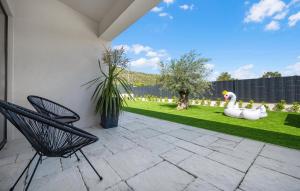 un patio con 2 sillas y un jardín en Stunning Home In Sibenik With Kitchen, en Šibenik 28 fotos más