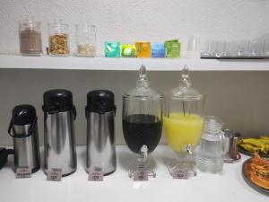 a kitchen counter with a blender and a glass of juice at Hotel Vila Planalto in Brasilia