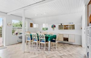 巴恩科普Three-Bedroom Holiday Home Bagenkop With Sea View 04的有绿色桌子和椅子的餐厅