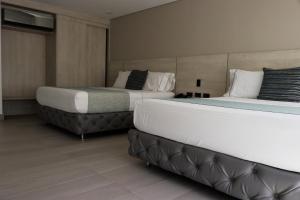 two beds in a hotel room with two bedsskirts at Hotel Loup in Medellín