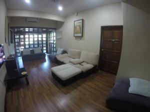 a living room with a couch and a table at Pan Sutera Homestay Comfortable Bali Experience in Alor Setar +5 photos