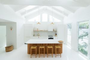a kitchen with white counters and a large window at La Casa Byron in Byron Bay