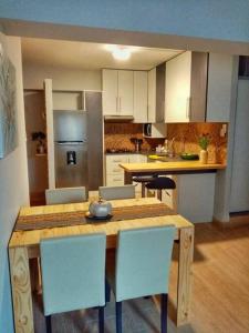une cuisine avec une table et des chaises en bois dans l'établissement Bonito y Moderno 1 o 2 dormitorios, à Lima