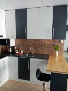 une cuisine avec des placards noirs et blancs et une table en bois dans l'établissement Bonito y Moderno 1 o 2 dormitorios, à Lima 1 autre photo