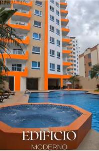 a building with a swimming pool in front of a building at Departamento Alfredd in Tonsupa