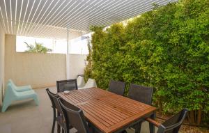 ein Holztisch und Stühle auf einer Terrasse in der Unterkunft Cozy Home In Marina Di Ragusa With Wifi in Marina di Ragusa