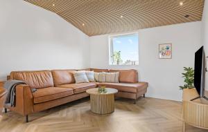 Una sala de estar con un sofá marrón y una mesa. en 4 Bedroom Amazing Home In Sydals, en Sarup