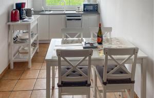 - une cuisine avec une table et 2 chaises ainsi qu'une bouteille de vin dans l'établissement Holiday Home Nowe Warpno Szczecinska, à Karszno